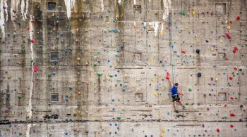 Rostock, Germany - May 27, 2016: A man boulder on a climbing wall in Rostock. The wall is part of an old bunker near the baltic sea.