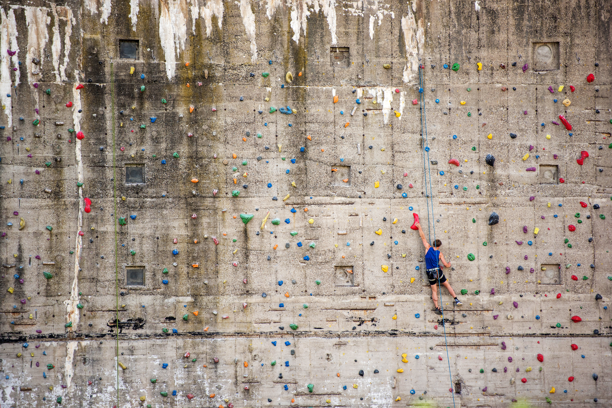 Rostock, Germany - May 27, 2016: A man boulder on a climbing wall in Rostock. The wall is part of an old bunker near the baltic sea.